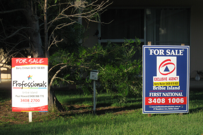 Two real estate signs selling one property, one claims to be exclusive.